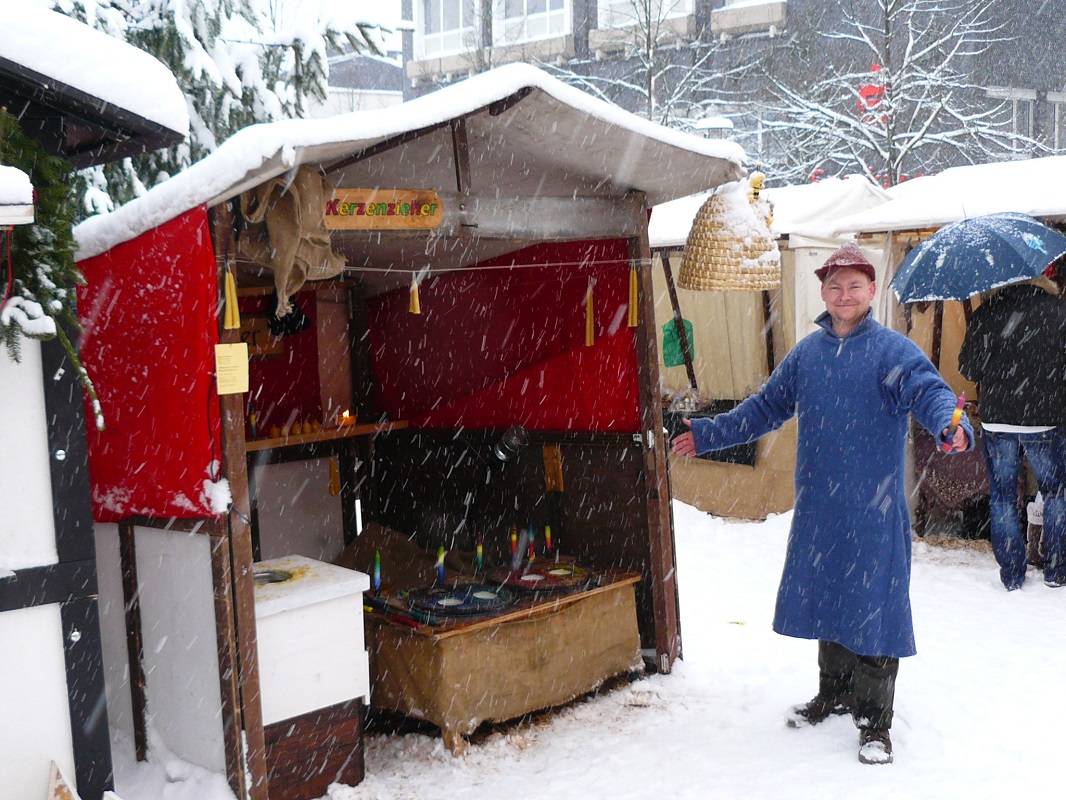 Foto Kerzenzieherei im Winter auf einem Weihnachtsmarkt bei Schneefall