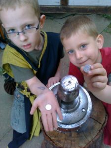 die zwei Kinder, Jungen, zeigen ihre frischen und neuen Glücksthaler